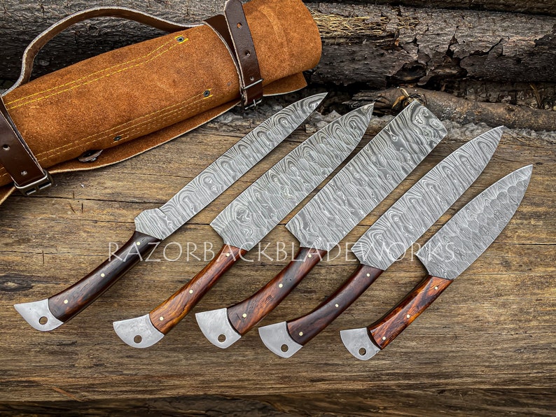 Damascus kitchen knives arranged with a leather roll